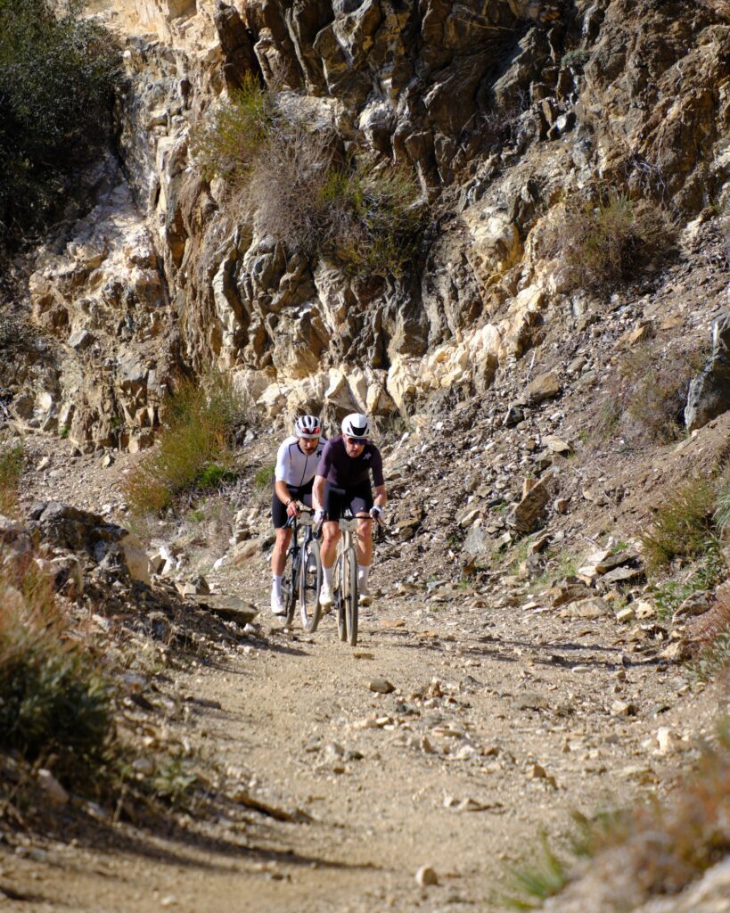Two riders descending a rocky gully