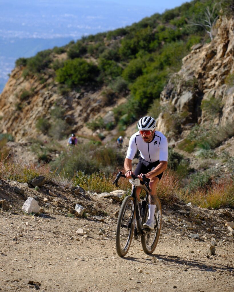 Rider climbing a rocky trail with a valley below