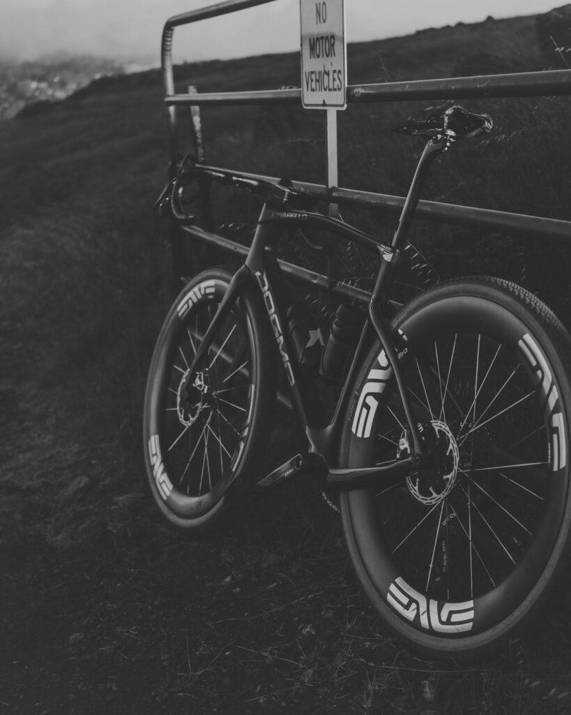 Pinarello Dogma GR leaning against a farm gate, in black and white