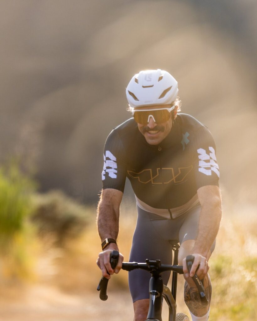 Close portrait of a rider in a white helmet on a trail, background blurred