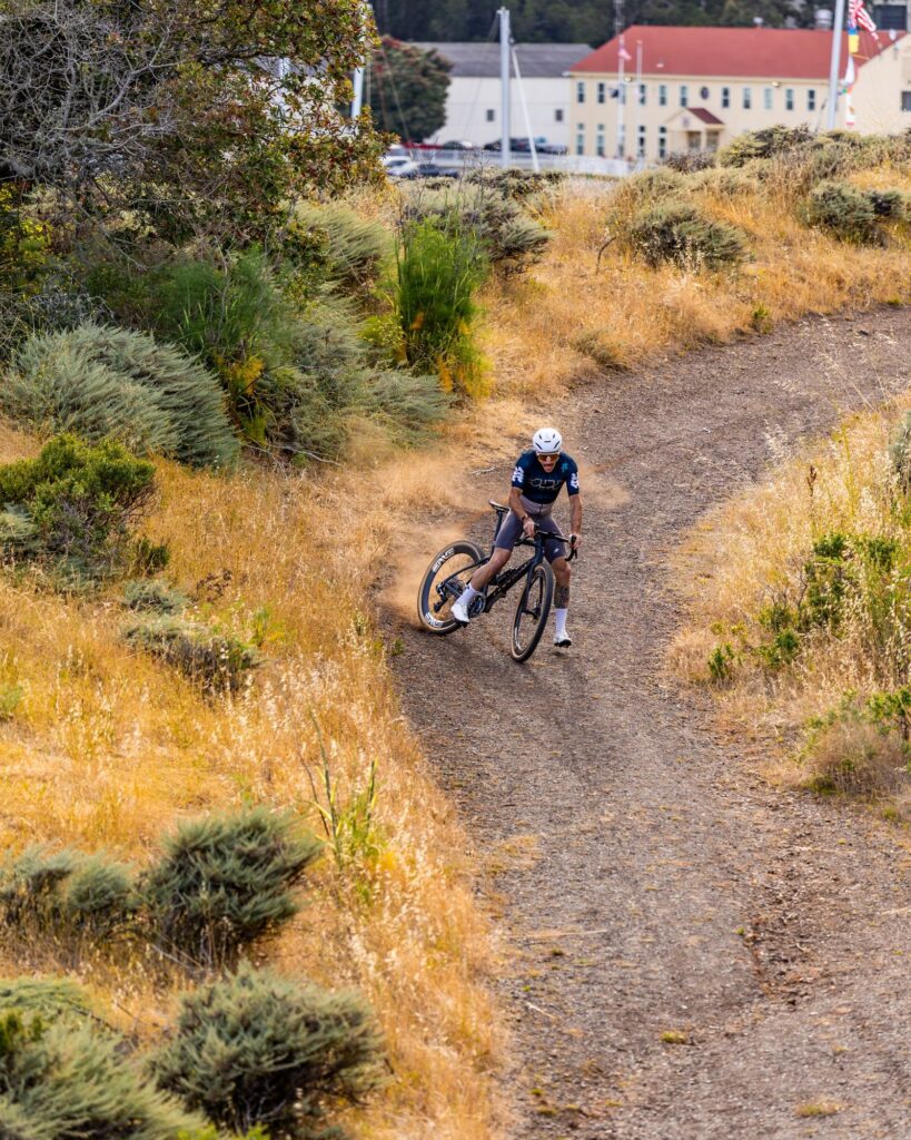 Rider descending a winding dirt path above a group of buildings